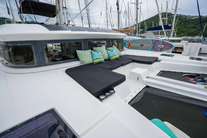  Yacht Photos Pics 2020 Lagoon 50 catamaran with cushioned deck seating and vibrant pillows in a marina setting.
