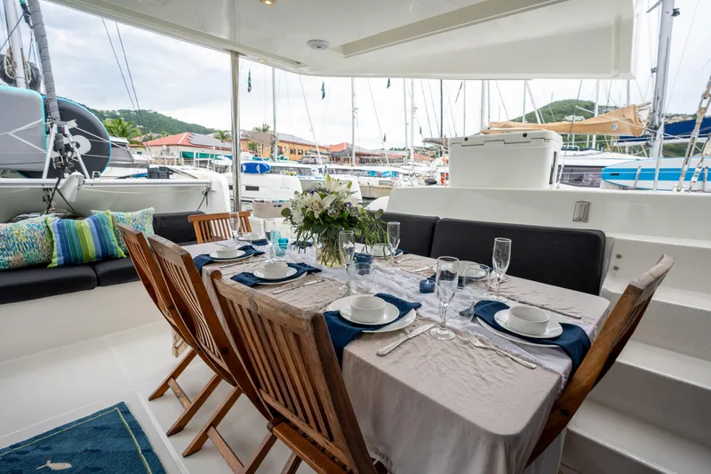  Yacht Photos Pics Elegant dining setup on a 2020 Lagoon 50 catamaran, docked at a marina.
