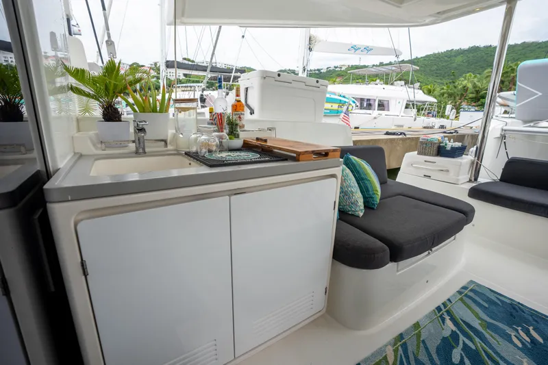  Yacht Photos Pics Outdoor kitchen on a 2020 Lagoon 50 catamaran with seating and lush greenery.