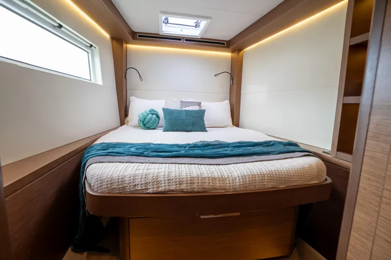  Yacht Photos Pics Luxurious cabin interior of 2020 Lagoon 50 yacht with cozy bed and modern lighting.