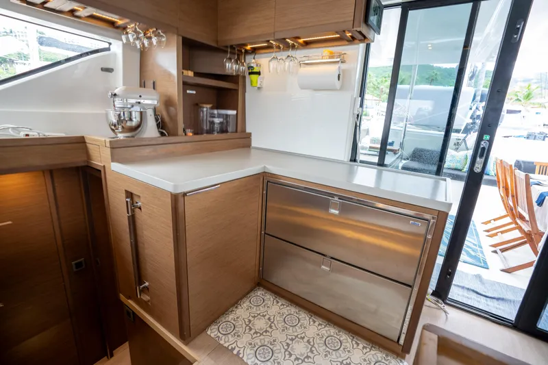  Yacht Photos Pics Modern kitchen interior on 2020 Lagoon 50 yacht with stainless steel appliances and wooden cabinetry.