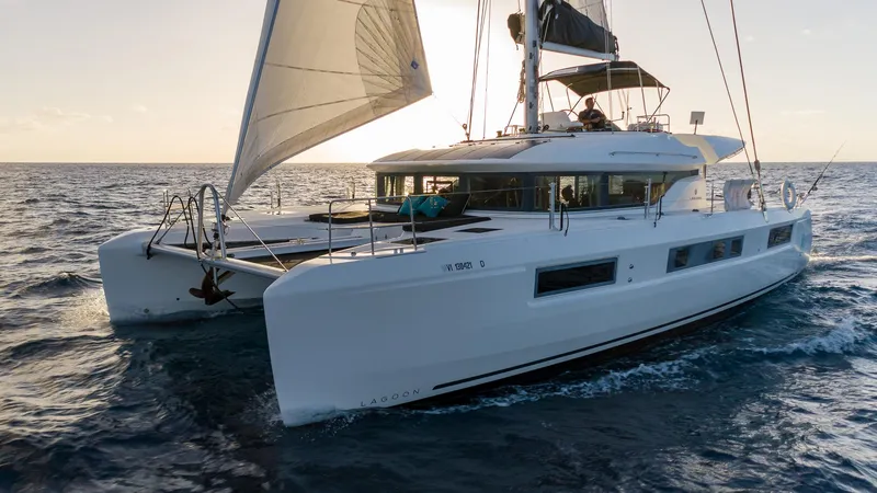  Yacht Photos Pics 2020 Lagoon 50 catamaran sailing on open sea at sunset.