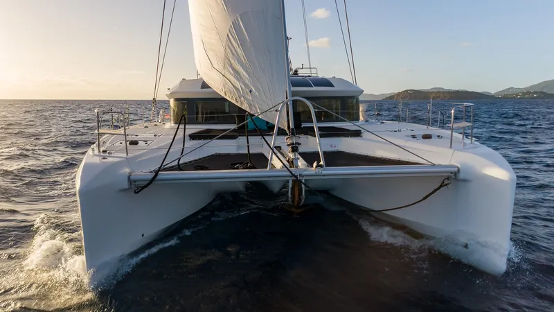  Yacht Photos Pics 2020 Lagoon 50 catamaran sailing on open sea at sunset.