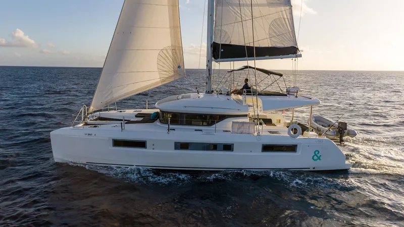  Yacht Photos Pics 2020 Lagoon 50 catamaran sailing on open sea at sunset.