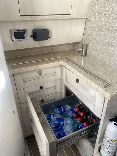 Relapse Yacht Photos Pics 2021 HCB 42 Lujo yacht interior with open drawer, stocked with bottled drinks.