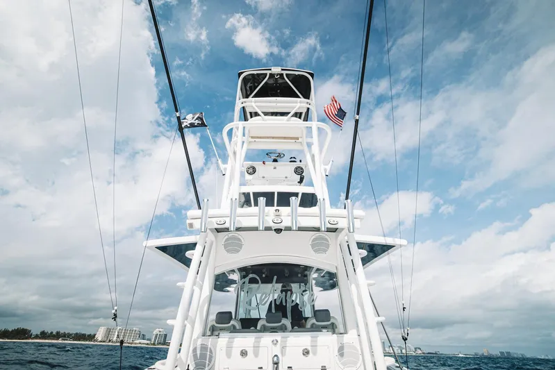 Relapse Yacht Photos Pics 2021 HCB 42 Lujo boat on open water with flags, under a cloudy sky.