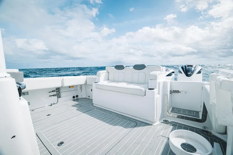 Relapse Yacht Photos Pics 2021 HCB 42 Lujo boat deck with seating, ocean view, and cloudy sky.