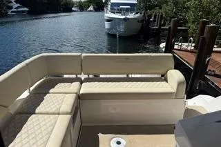  Yacht Photos Pics 2021 Regal 38 XO boat with beige seating, docked by a serene waterway.