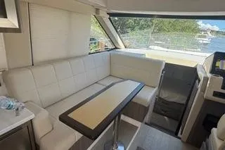  Yacht Photos Pics 2021 Regal 38 XO yacht interior with white seating and table, featuring large windows.