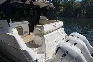  Yacht Photos Pics 2021 Regal 38 XO boat with Yamaha engines docked by a serene waterway.