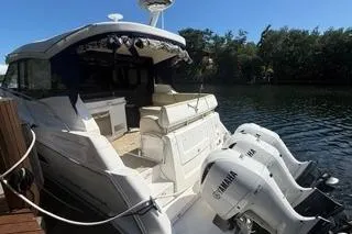  Yacht Photos Pics 2021 Regal 38 XO boat with Yamaha engines docked by a serene waterway.