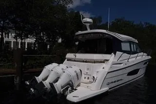  Yacht Photos Pics 2021 Regal 38 XO boat docked with triple outboard engines, surrounded by trees.