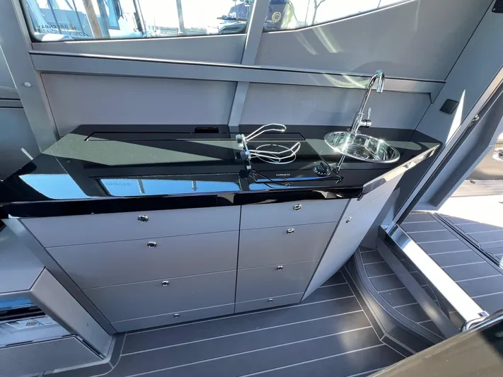 G10 Yacht Photos Pics Modern kitchenette in 2024 G-Force 10 yacht with sleek black countertop and stainless steel sink.