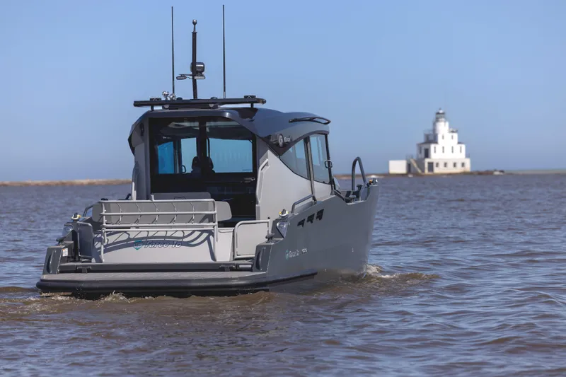 G10 Yacht Photos Pics 2024 G-Force 10 boat on water with distant lighthouse in background.