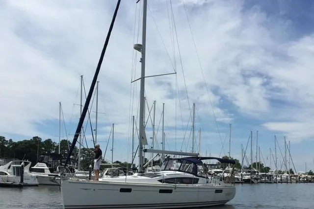 Pura Vida Yacht Photos Pics 2007 Jeanneau Sun Odyssey 42 DS sailboat docked in a marina under a cloudy sky.