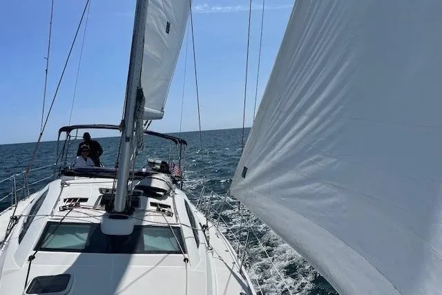 Pura Vida Yacht Photos Pics 2007 Jeanneau Sun Odyssey 42 DS sailing on open sea under clear blue sky.