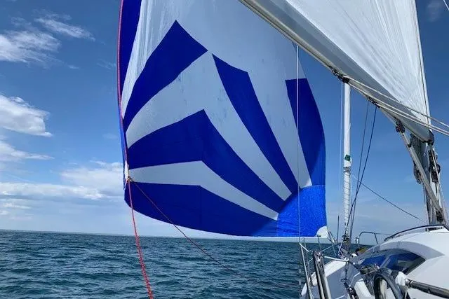 Pura Vida Yacht Photos Pics Jeanneau Sun Odyssey 42 DS sailing with vibrant blue and white spinnaker, 2007 model.