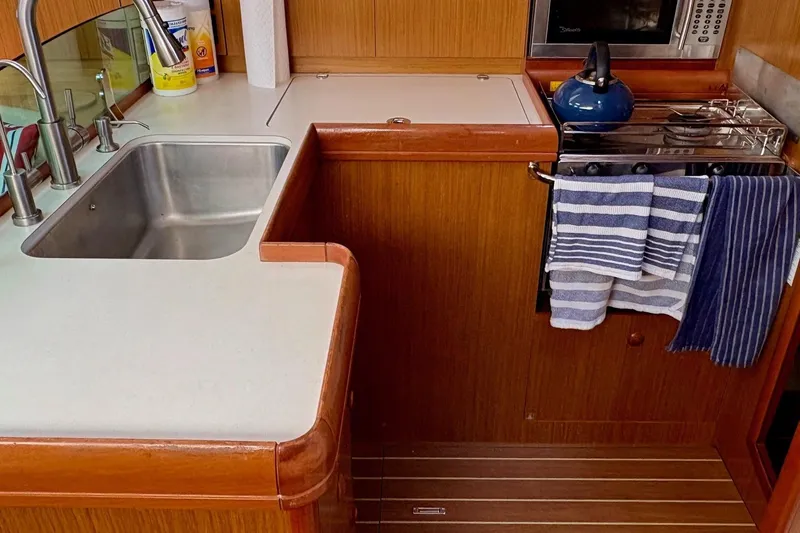 Pura Vida Yacht Photos Pics Galley kitchen in 2007 Jeanneau Sun Odyssey 42 DS sailboat with sink and stove.