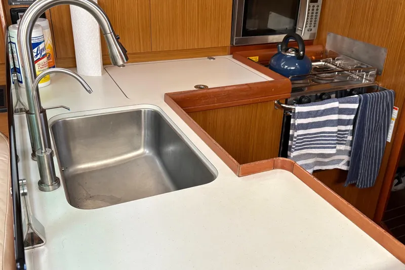 Pura Vida Yacht Photos Pics Galley kitchen in 2007 Jeanneau Sun Odyssey 42 DS sailboat with sink and stove.
