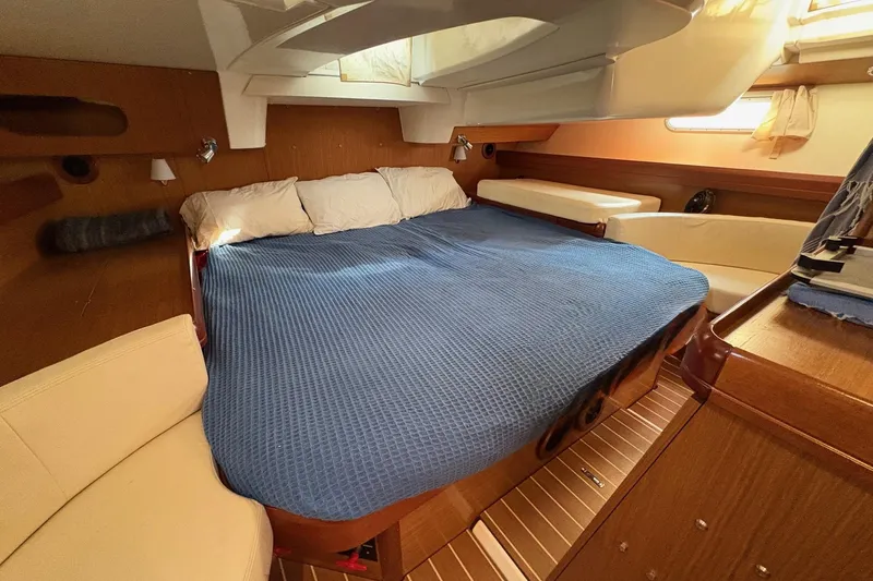 Pura Vida Yacht Photos Pics Cozy cabin interior of 2007 Jeanneau Sun Odyssey 42 DS with blue bedding.