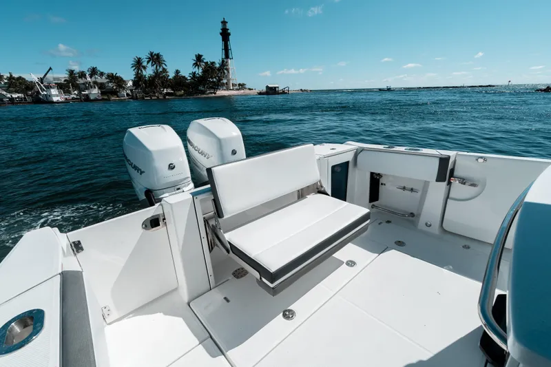  Yacht Photos Pics 2020 Blackfin 332 CC boat with dual Mercury engines, ocean view, and lighthouse in background.