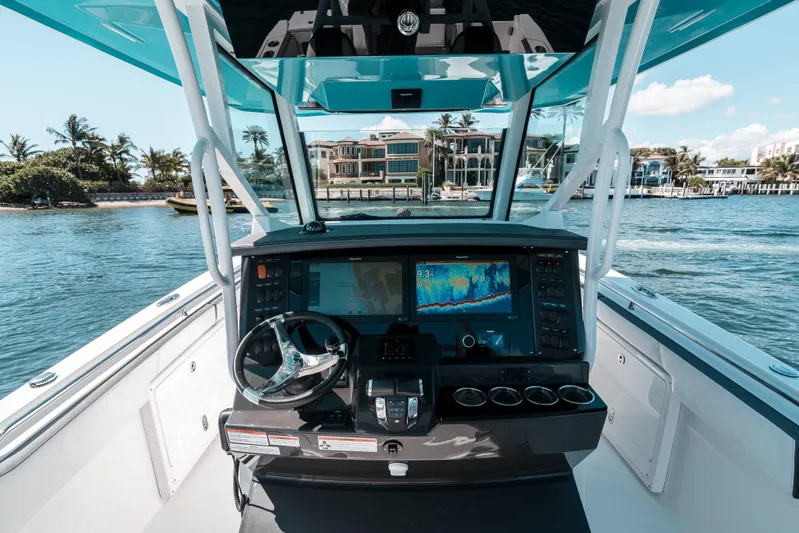  Yacht Photos Pics 2020 Blackfin 332 CC boat cockpit with advanced navigation system, steering wheel, and ocean view.