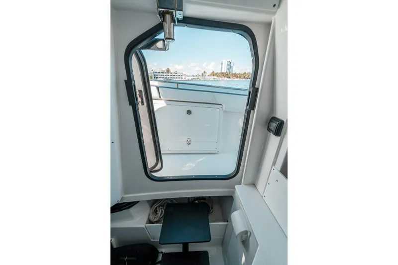  Yacht Photos Pics Interior view of 2020 Blackfin 332 CC boat cabin with open door and ocean backdrop.