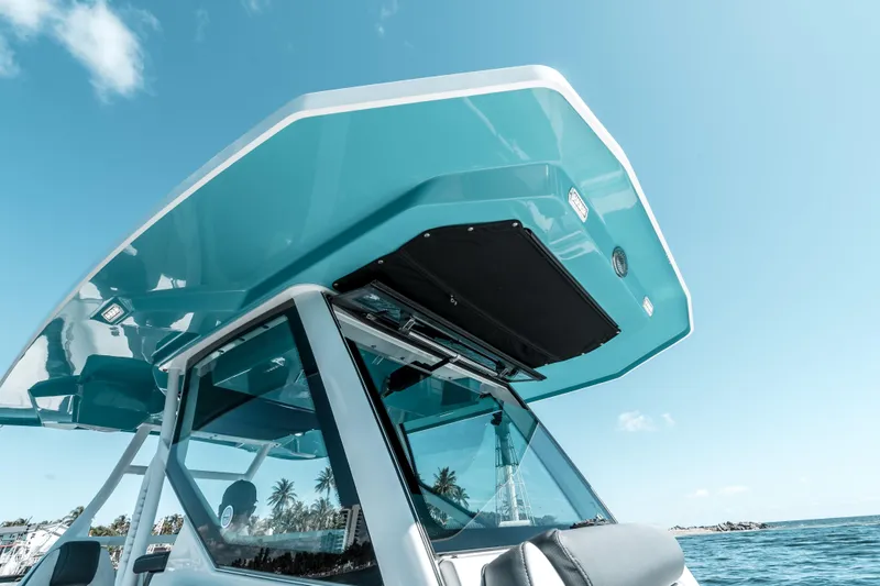  Yacht Photos Pics 2020 Blackfin 332 CC boat with sleek design, blue hardtop, and clear sky background.