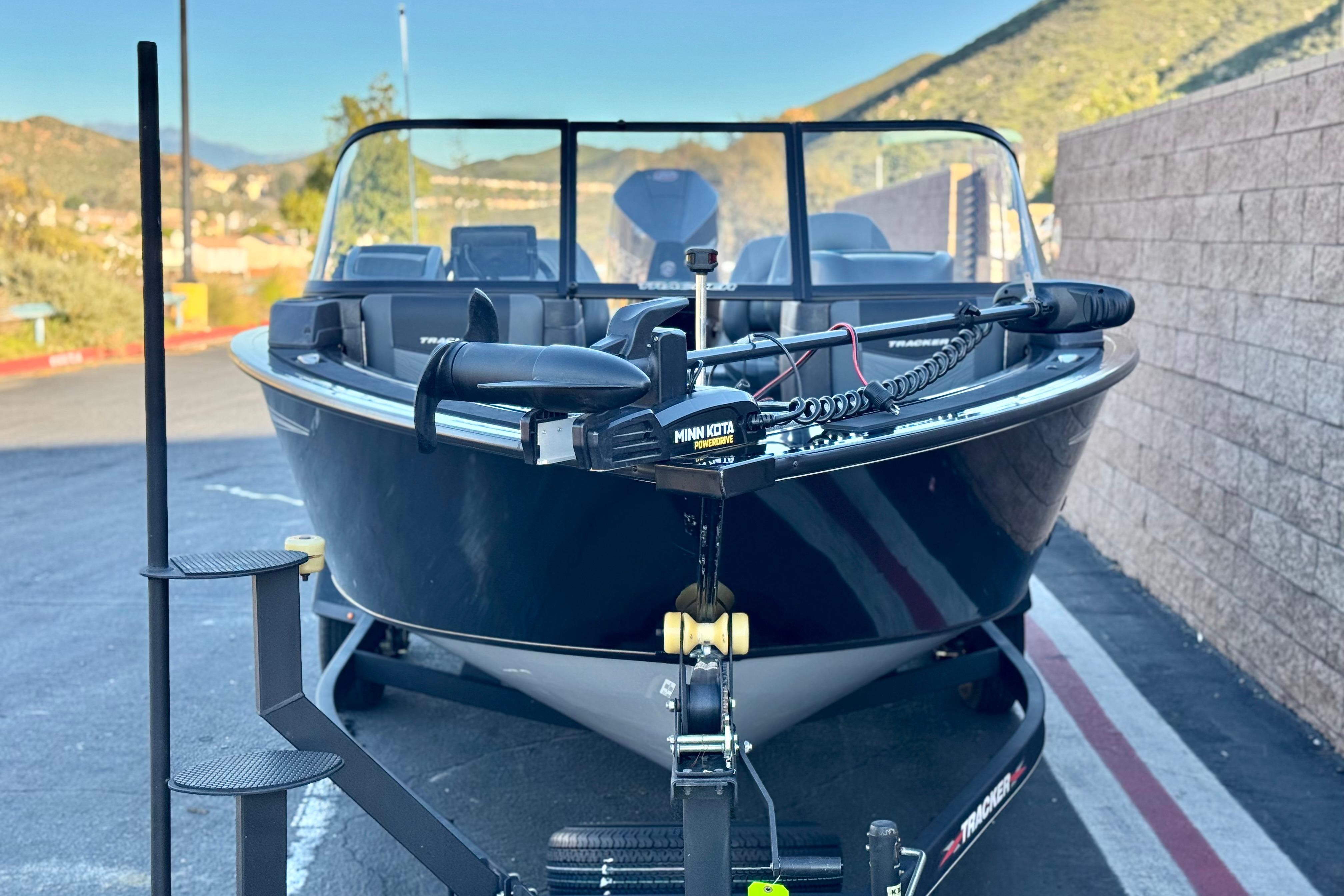 2023 Tracker Targa V-19 WT boat on trailer, parked outdoors with scenic background.