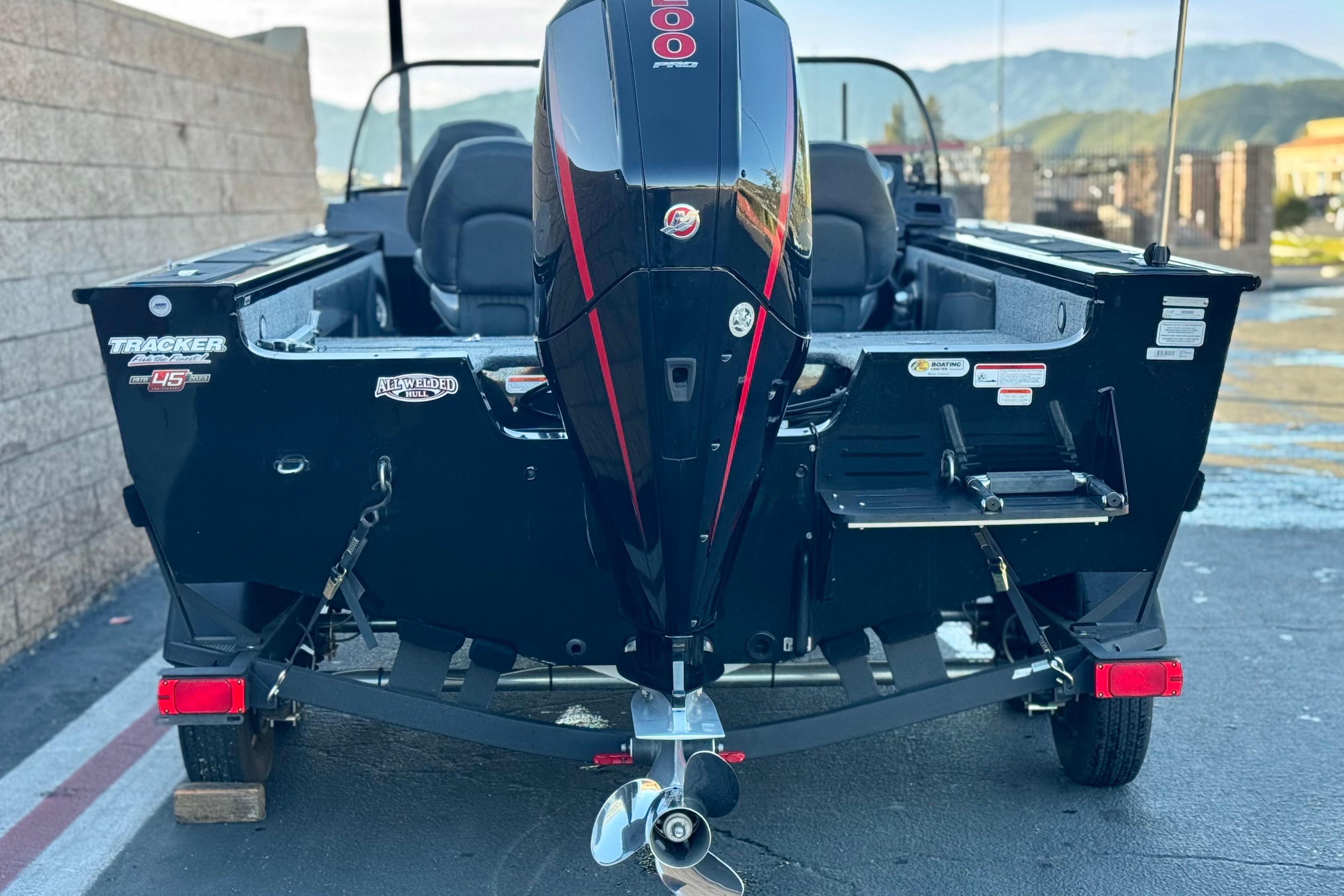 2023 Tracker Targa V-19 WT boat with powerful outboard motor, parked outdoors.