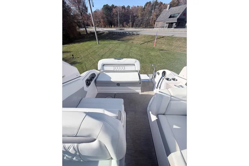  Yacht Photos Pics 2019 Regal 28 Express boat interior with white seating and cup holders, parked on grass.