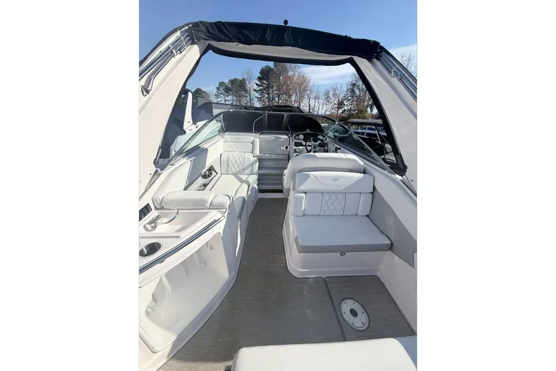  Yacht Photos Pics 2019 Regal 28 Express boat interior with seating and helm, under clear blue sky.