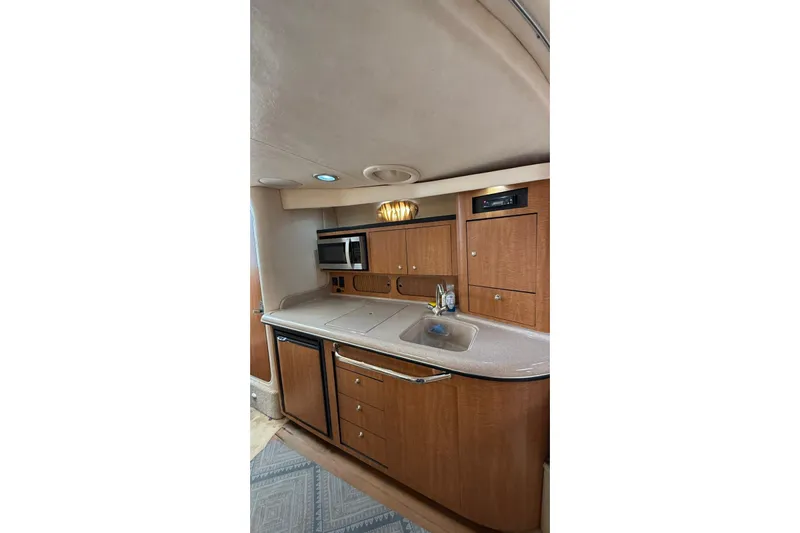  Yacht Photos Pics 2006 Sea Ray 340 Sundancer interior kitchen with wood cabinets, sink, and microwave.