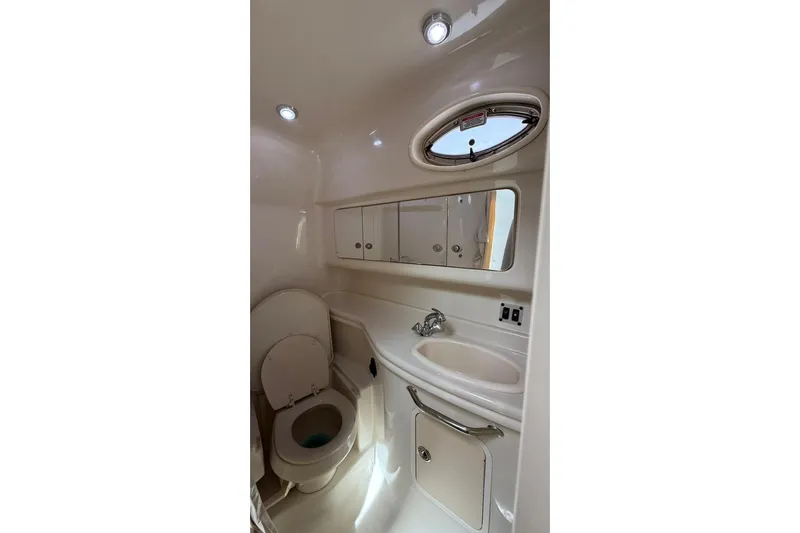  Yacht Photos Pics 2006 Sea Ray 340 Sundancer bathroom with toilet, sink, mirror, and porthole window.