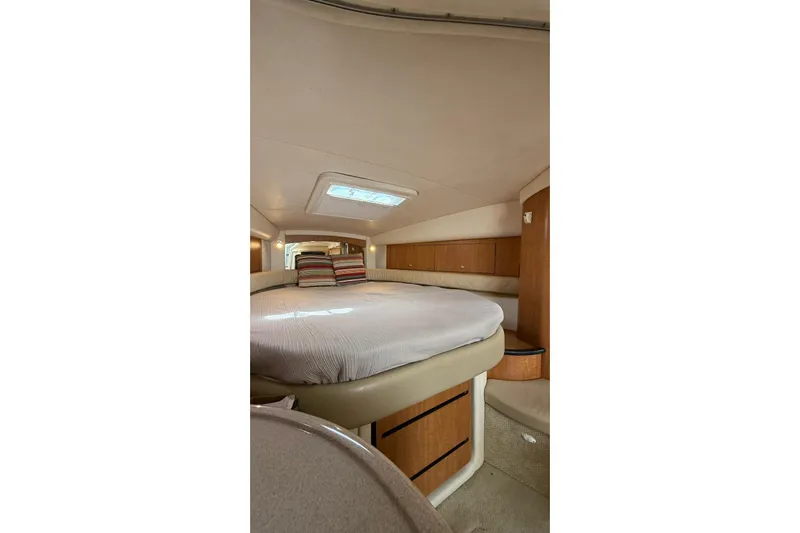  Yacht Photos Pics 2006 Sea Ray 340 Sundancer cabin interior with bed and striped pillows.