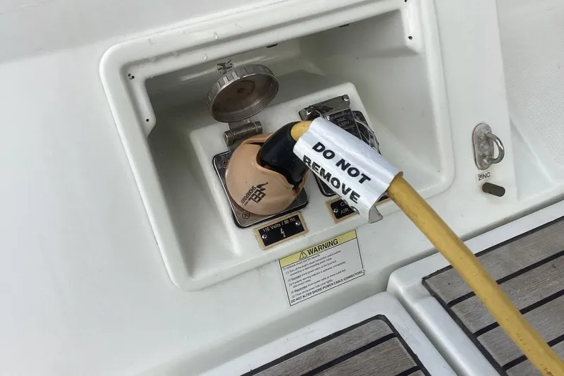 At Last Yacht Photos Pics Power connection on 2012 Beneteau Oceanis 45 sailboat with "Do Not Remove" label.