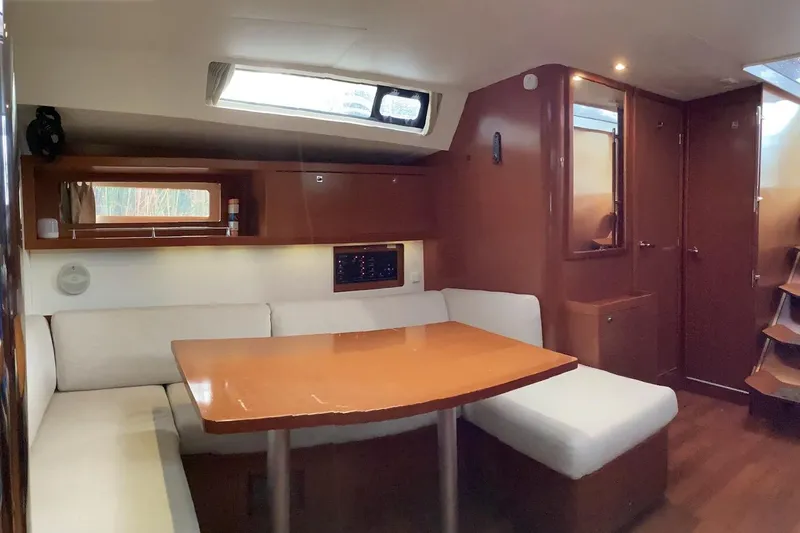 At Last Yacht Photos Pics Interior of 2012 Beneteau Oceanis 45 yacht with cozy seating and wooden table.