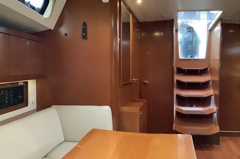 At Last Yacht Photos Pics Interior of 2012 Beneteau Oceanis 45 yacht with wooden finish and seating area.