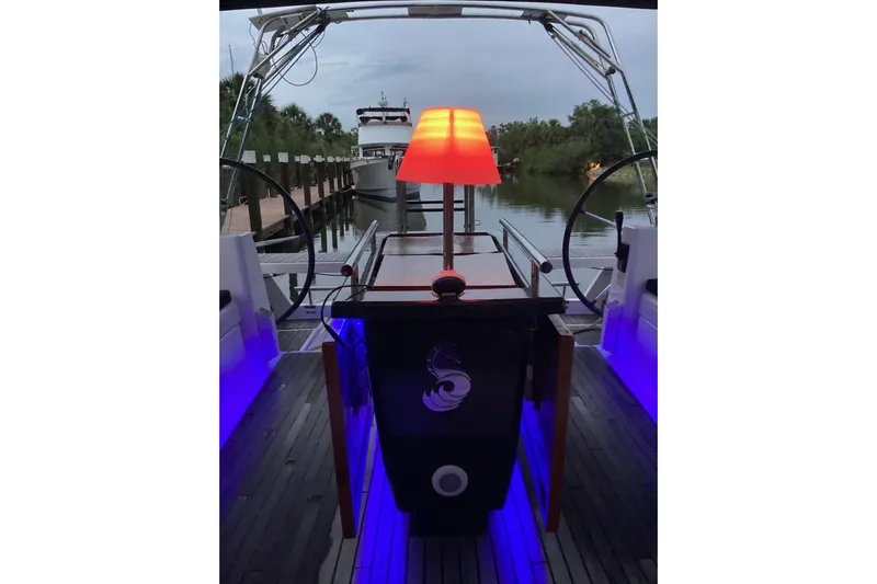 At Last Yacht Photos Pics Beneteau Oceanis 45 yacht interior with ambient lighting and a red lamp, docked in a serene marina.