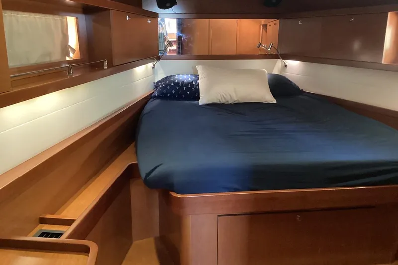 At Last Yacht Photos Pics Cozy cabin interior of 2012 Beneteau Oceanis 45 yacht with wooden finish and comfortable bedding.