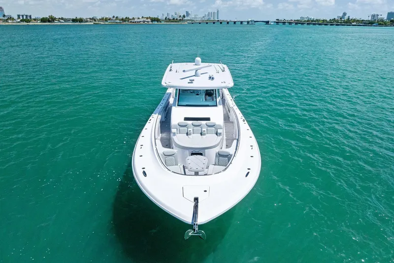  Yacht Photos Pics 2025 HCB 56 Suenos GIX luxury yacht on turquoise water, city skyline in background.