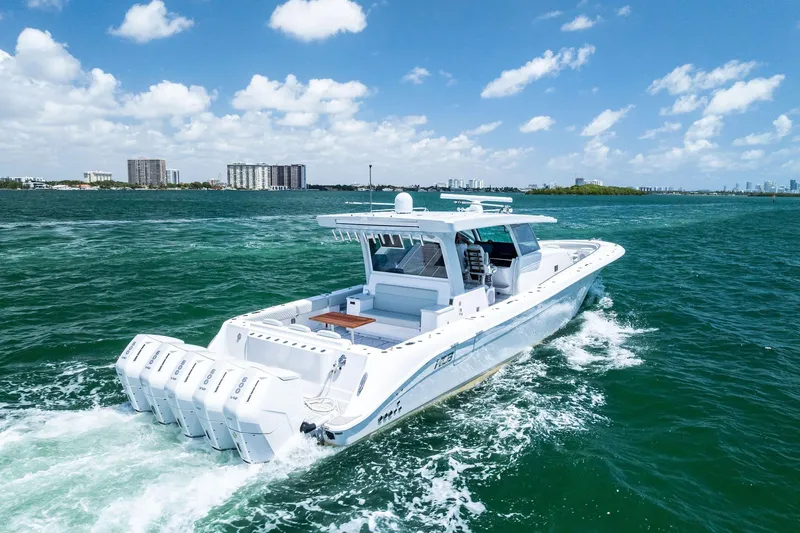  Yacht Photos Pics 2025 HCB 56 Suenos GIX luxury boat cruising on open water under a clear blue sky.