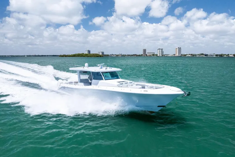  Yacht Photos Pics 2025 HCB 56 Suenos GIX yacht cruising on turquoise water under a partly cloudy sky.