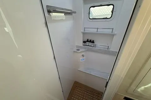  Yacht Photos Pics 2025 HCB 56 Suenos GIX boat bathroom with shelves, window, and toiletries.