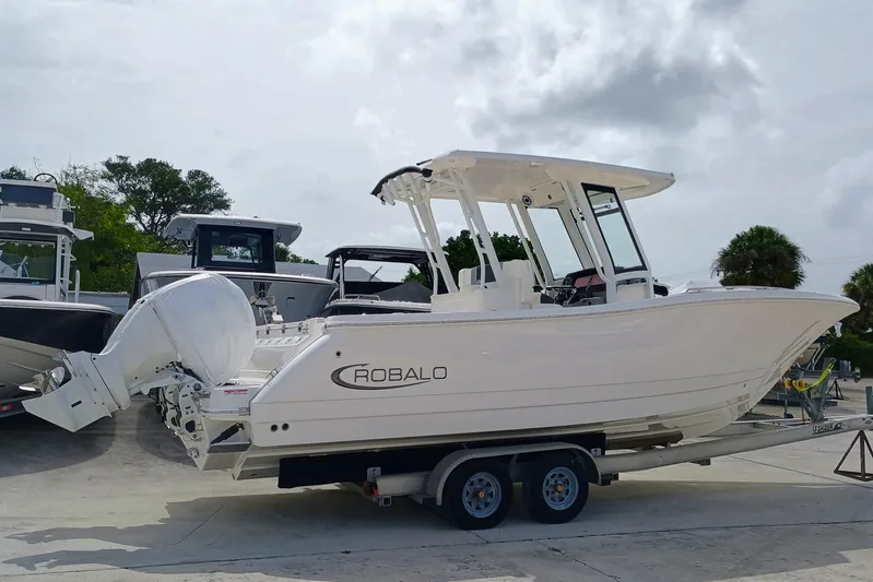 270-152 Yacht Photos Pics 2025 Robalo R270 Center Console boat on trailer, parked outdoors.