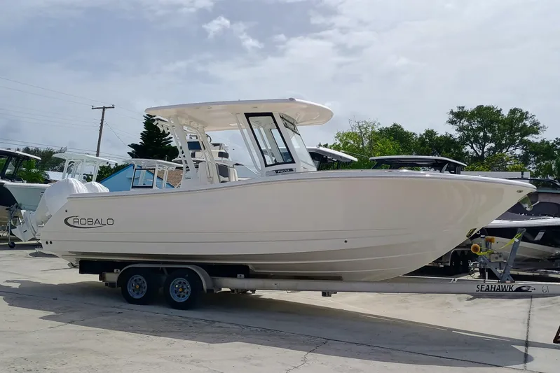 270-152 Yacht Photos Pics 2025 Robalo R270 Center Console boat on trailer, parked outdoors.