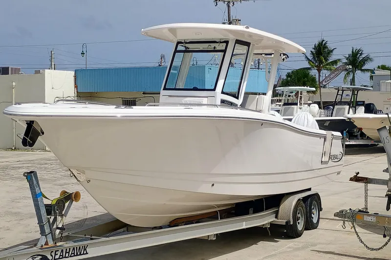 270-152 Yacht Photos Pics 2025 Robalo R270 Center Console boat on trailer, parked outdoors.