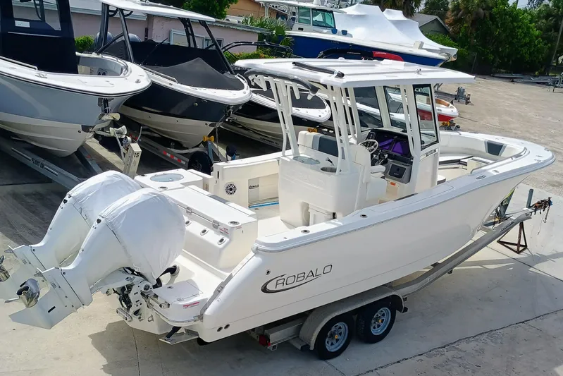 270-152 Yacht Photos Pics 2025 Robalo R270 Center Console boat on trailer, featuring dual engines.