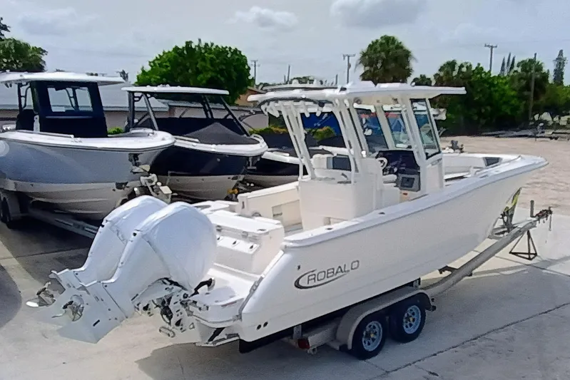 270-152 Yacht Photos Pics 2025 Robalo R270 Center Console boat on trailer, parked outdoors.