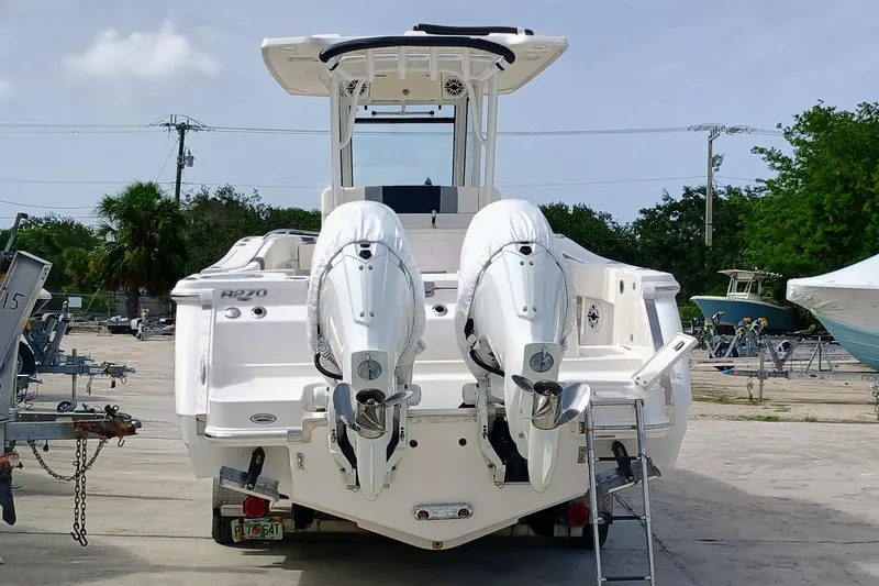 270-152 Yacht Photos Pics 2025 Robalo R270 Center Console boat with dual engines, parked outdoors.